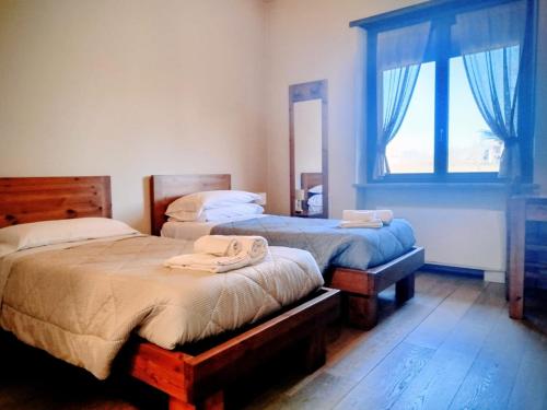 a bedroom with two twin beds and a window at La Mandulera in Rivalta di Torino