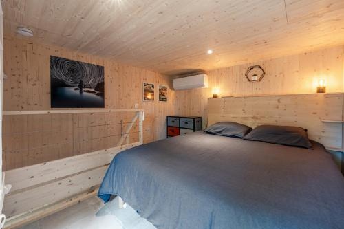 a bedroom with a bed and a tv on the wall at Le KuboLodge - Tiny House premium in Jacou