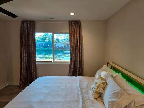 a bedroom with a large bed with a window at Lakefront Retreat • Private Yard + Fireplace in Clearlake Oaks