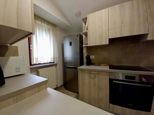 una cucina con mobili in legno e un frigorifero di Imperial Rooms a Grosotto