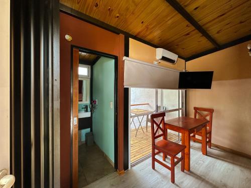 una sala da pranzo con tavolo e sedie e un balcone di La Cabaña a Santa Clara del Mar
