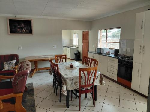 a kitchen and dining room with a table and chairs at VSA SELF CATERING accommodation unit 2 in Newcastle