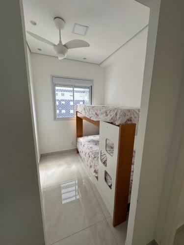 a small bedroom with a bed and a window at Refúgio Brisa e Mar in Mongaguá