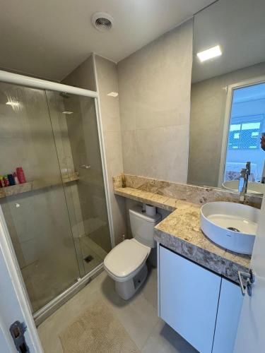 a bathroom with a toilet and a sink and a shower at Refúgio Brisa e Mar in Mongaguá