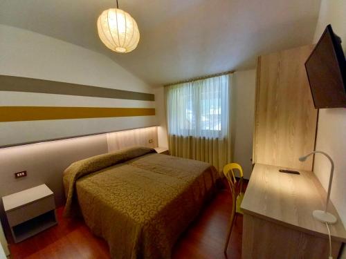 una piccola camera da letto con un letto e una finestra di Imperial Rooms a Grosotto