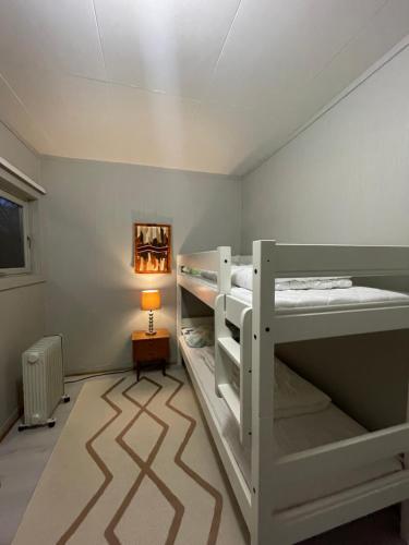 two bunk beds in a room with a lamp at Nordnorge Self-Check-In in Majavatn