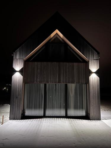 a building with a large glass door at night at Stodoła Na Widoku z Balią in Radków