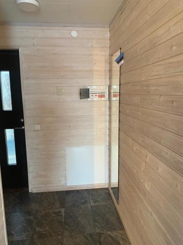 a room with a wooden wall with a white door at Vesilinnu 2 in Aabla