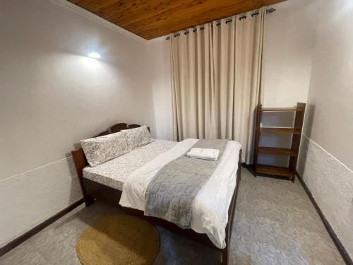 a small bedroom with a bed and a window at Toiwo Residence Arusha in Arusha
