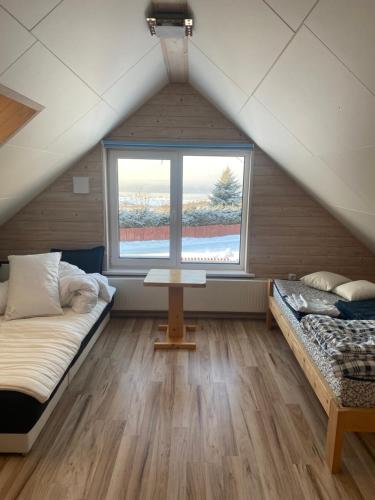 a attic room with two beds and a window at Vesilinnu 2 in Aabla