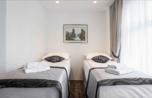 a room with three beds with towels on them at Hotel Grad in Sarajevo