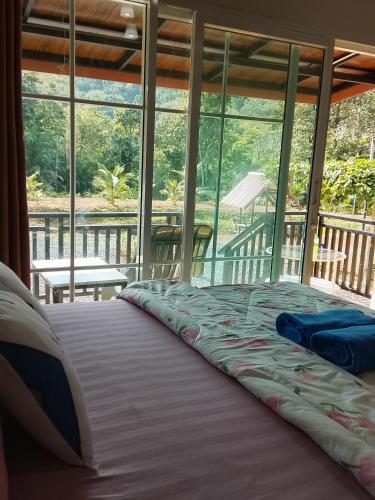 a large bed in a room with a balcony at A Nature House in Ko Lanta Yai