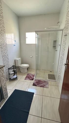 a bathroom with a glass shower and a toilet at Recanto Vó Rosa in Socorro