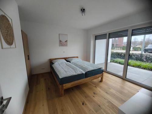 a bedroom with a bed and a large window at SeeZeitApartments Whg 28 in Lembruch