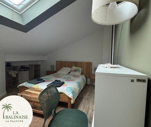 una camera da letto con un letto, un tavolo e delle sedie di La Balinaise a Les Mathes