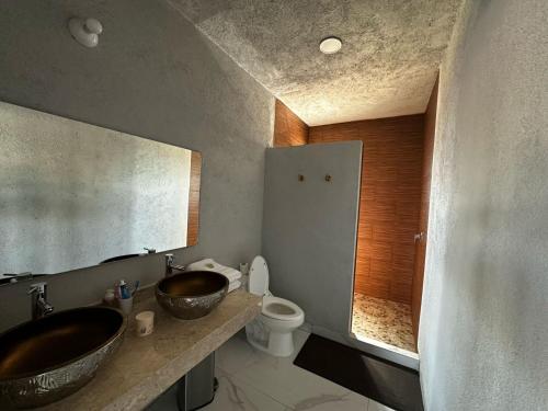a bathroom with two sinks and a toilet in it at Casa de los Agaves in Bernal