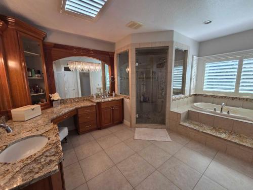 un bagno con due lavandini, una doccia e una vasca di Luxury Family Estate Near PDX, Theater, Sauna & Game Room a Happy Valley