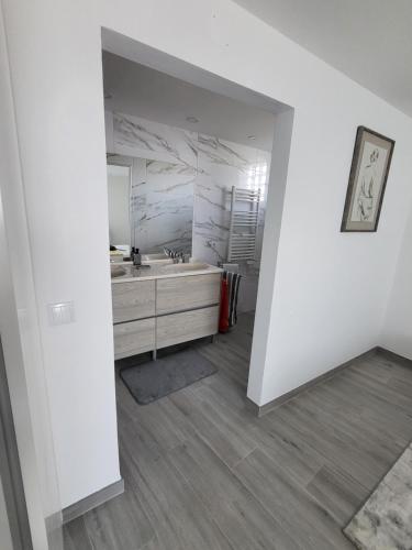 a white bathroom with a sink and a mirror at Portela ALR in Portela da Memória