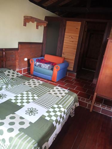 een kamer met een bed en een stoel erin bij Descanso Rural Colombia in Marsella
