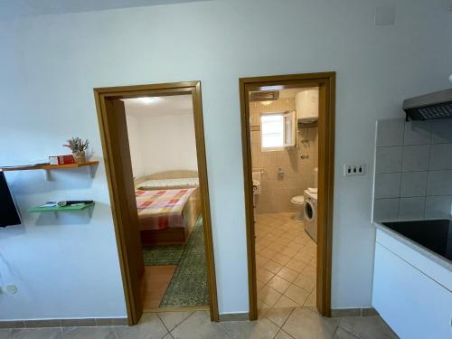 bagno con porta che conduce a una camera da letto di Apartment Orbanić Cres a Cres