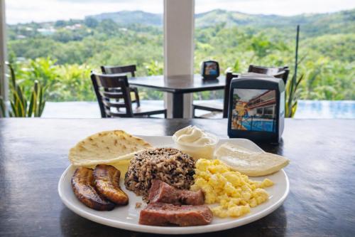 un piatto di cibo per la colazione su un tavolo di Hotel Puerto San Luis a Tilarán