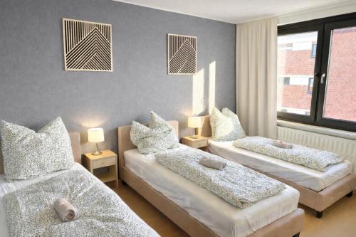 a bedroom with two beds with pillows on them at Schöne 3-Zimmer City-Wohnung in Neumünster