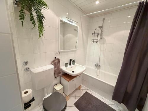 a white bathroom with a sink and a toilet at Schöne 3-Zimmer City-Wohnung in Neumünster