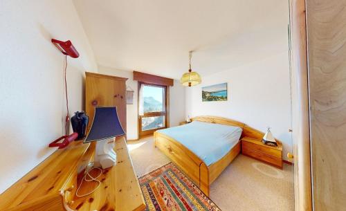 a bedroom with a bed and a desk with a lamp at Beautiful mountain apartment in Leysin