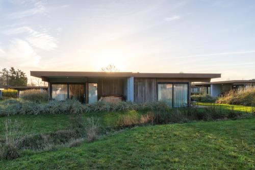 Garden Suites - Duinhotel in Burgh-Haamstede zeeland في برغ هالمستاد: منزل حديث مع ساحة خضراء