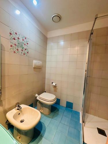 a bathroom with a toilet and a sink and a shower at Hotel Oasi Este in Este