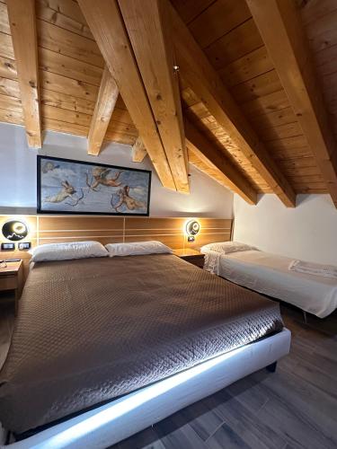 two beds in a room with wooden ceilings at Hotel Oasi Este in Este