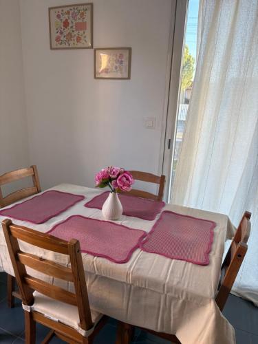 een tafel met daarop een vaas met bloemen bij Maison entière avec jardin , Proche Bordeaux, Rocade et Arkéa Arena in Bouliac