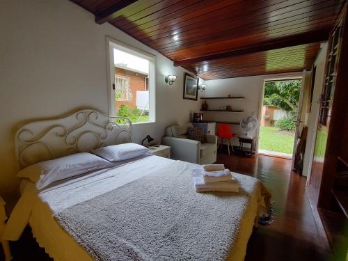 a bedroom with a large bed and a large window at Pousada dos Chalés - Araras in Araras Petropolis