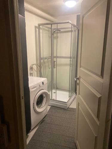 a bathroom with a shower and a washing machine at Solsidan 1 in Karlstad