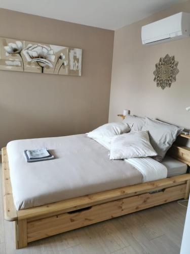 a bedroom with a wooden bed with white sheets and pillows at maison de village in Renaison