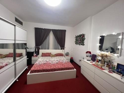 a bedroom with a large bed and a mirror at Pearl Studio Apartments in Abu Dhabi