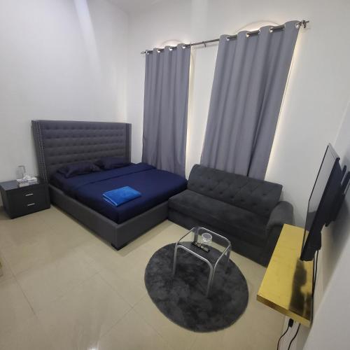 a living room with a bed and a couch at Pearl Studio Apartments in Abu Dhabi