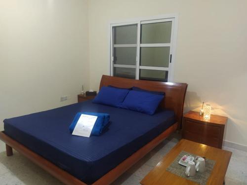 a bedroom with a bed with blue sheets and blue pillows at Pearl Studio Apartments in Abu Dhabi