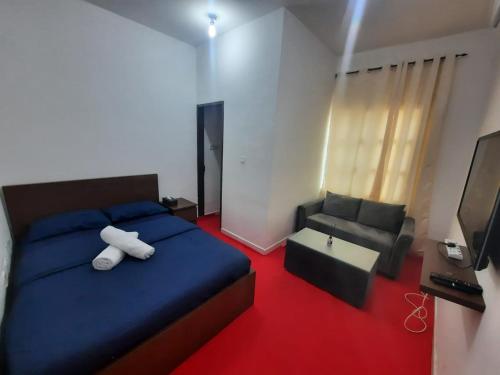 a bedroom with a blue bed and a couch at Pearl Studio Apartments in Abu Dhabi