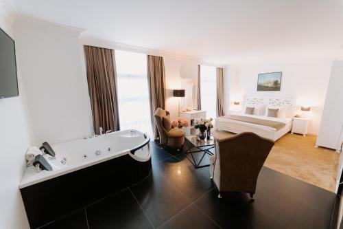 una camera d'albergo con vasca e una camera da letto di Golden Hotel a Pristina