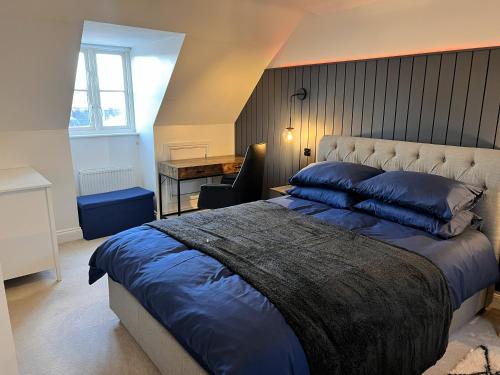 a bedroom with a large bed and a desk at Siskin House in Wickham Market
