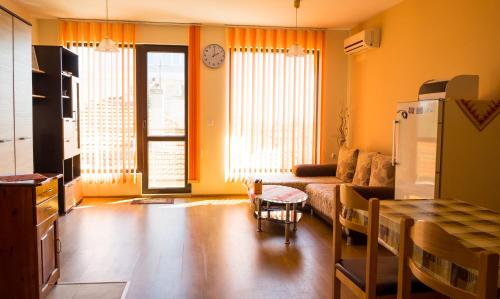 DDenko Apartment في مدينة بورغاس: غرفة معيشة مع أريكة وطاولة
