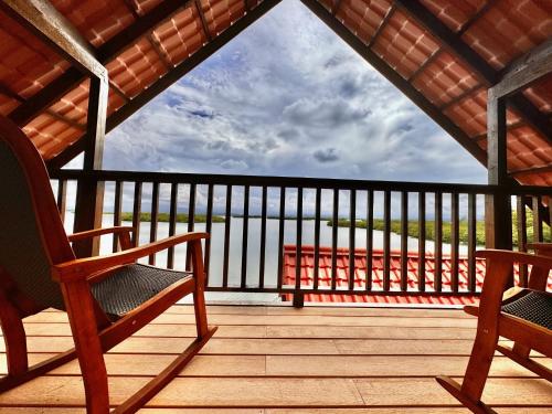 un portico con due sedie a dondolo su un ponte di legno di Six Pillars Resort a Bocas del Toro
