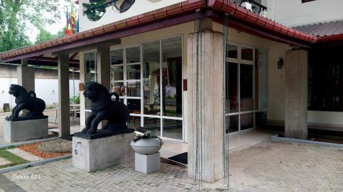 two statues of lions in front of a building at Sadula Holiday Resort in Anuradhapura