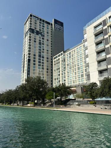 a view of a large building from a body of water at Lux Loft Apt Rio Santa Lucia King size, Swim Pool, Free Parking, Gym, Kids Club in Monterrey