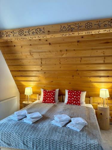 a bedroom with a large bed with red pillows at Rezydencja Kojsowka in Witów
