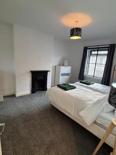 a bedroom with a large bed and a fireplace at Folly Field in Haworth