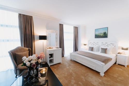 una camera bianca con un letto e un tavolo con fiori di Golden Hotel a Pristina