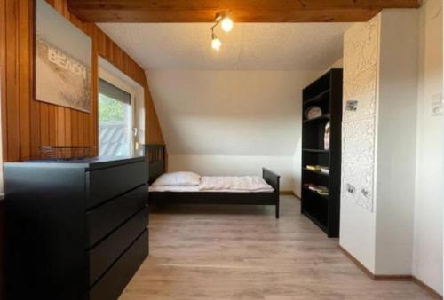 a bedroom with a bed and a dresser in a room at Ferienhaus Seestern in Dornum