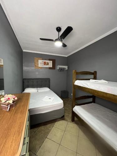 a room with two bunk beds and a table at Hostel Anprado #5 Kit café incluso, Próx-Aeroporto de Guarulhos in Guarulhos